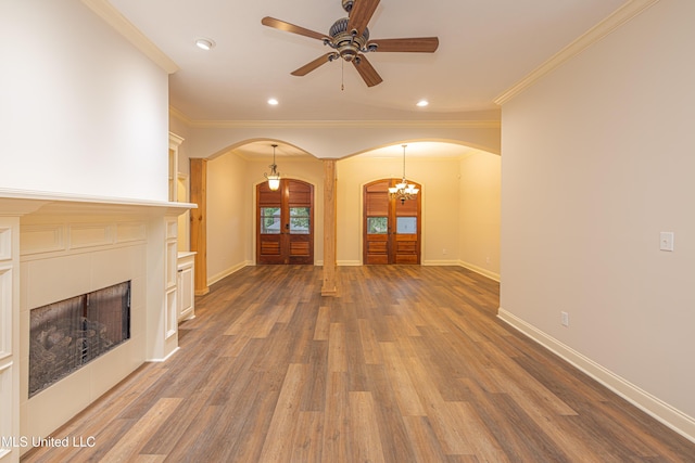130 Covey Run, Madison, MS 39110 - unfurnished living room featuring arched walkways, crown molding, wood finished floors, a ceiling fan, and french doors