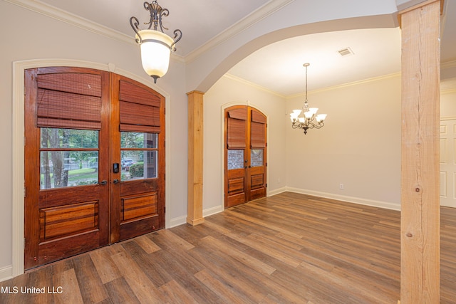 130 Covey Run, Madison, MS 39110 - foyer with french doors, arched walkways, wood finished floors, a chandelier, and crown molding