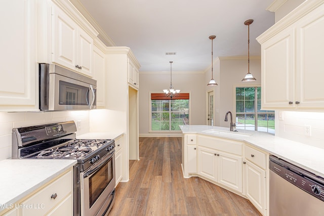 130 Covey Run, Madison, MS 39110 - kitchen featuring appliances with stainless steel finishes, light wood-type flooring, backsplash, a peninsula, and crown molding