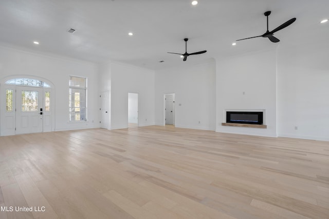 unfurnished living room featuring ornamental molding, light hardwood / wood-style flooring, and ceiling fan