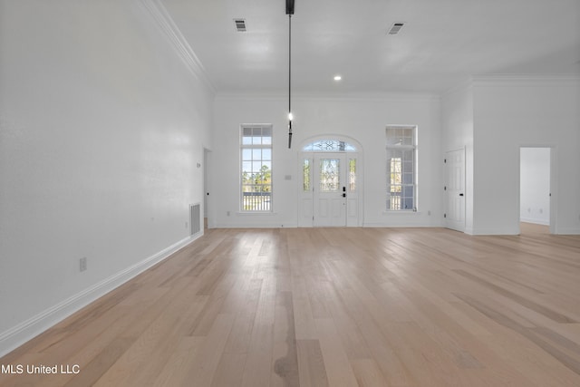 unfurnished living room featuring crown molding and light hardwood / wood-style flooring