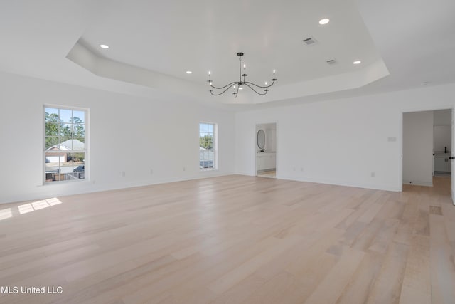 interior space featuring a chandelier, a tray ceiling, and light hardwood / wood-style floors