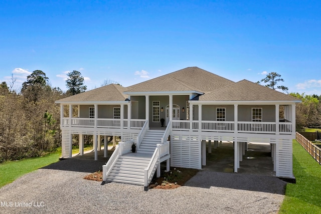 raised beach house featuring a carport and a porch