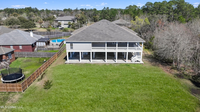 rear view of house with a yard and a sunroom