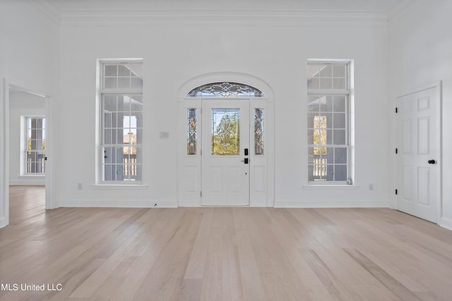 foyer featuring ornamental molding and light wood-type flooring