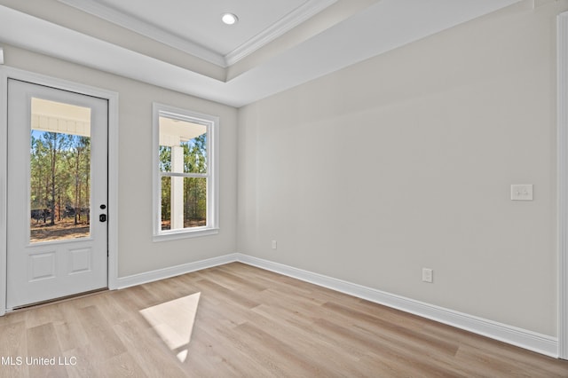 spare room featuring ornamental molding and light hardwood / wood-style flooring