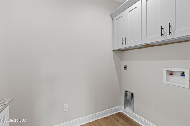 washroom with hookup for an electric dryer, hookup for a washing machine, cabinets, and light wood-type flooring