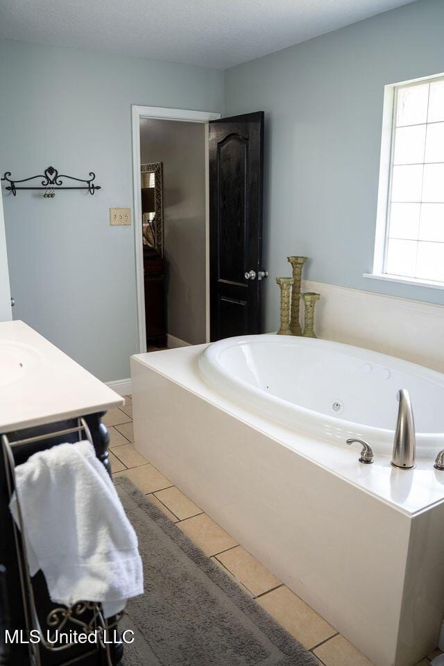 6816 Natchez St, Biloxi, MS 39532 - bathroom featuring a whirlpool tub, tile patterned flooring, and vanity