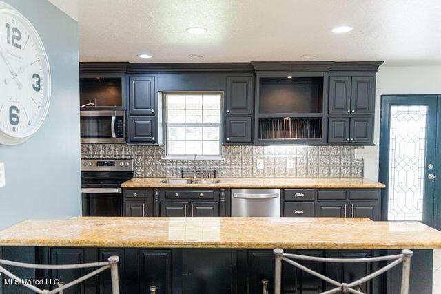 6816 Natchez St, Biloxi, MS 39532 - kitchen featuring stainless steel appliances, backsplash, light stone countertops, recessed lighting, and gray cabinets