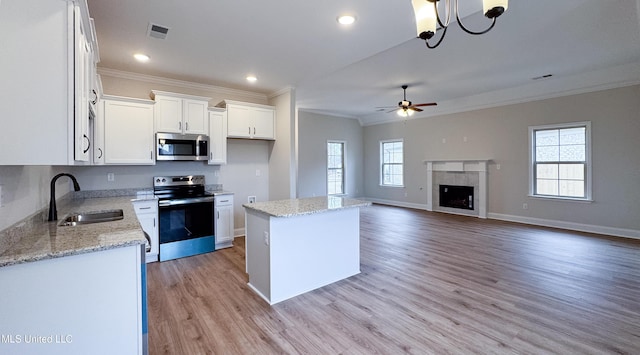 kitchen with visible vents, crown molding, plenty of natural light, stainless steel appliances, and a sink