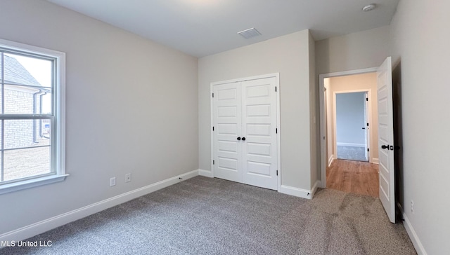 unfurnished bedroom featuring a closet, baseboards, and carpet floors