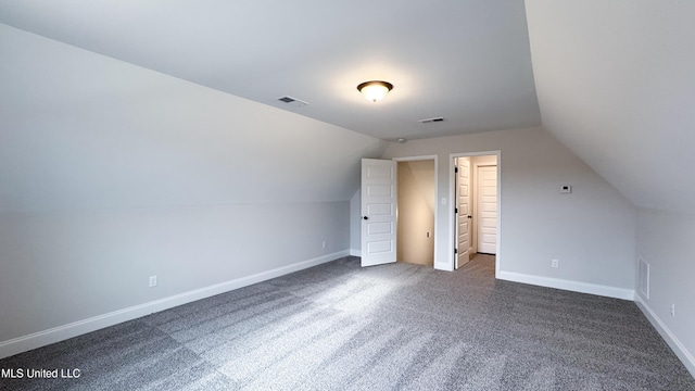 additional living space with vaulted ceiling, baseboards, and visible vents