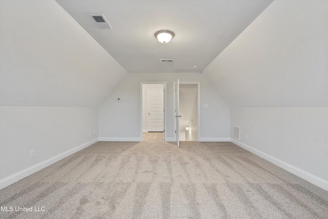 additional living space with visible vents, baseboards, and lofted ceiling