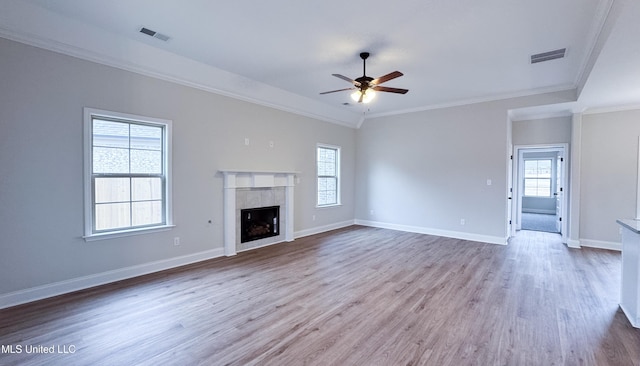 unfurnished living room with a tiled fireplace, visible vents, and wood finished floors