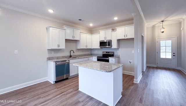 kitchen with visible vents, crown molding, appliances with stainless steel finishes, white cabinetry, and a sink