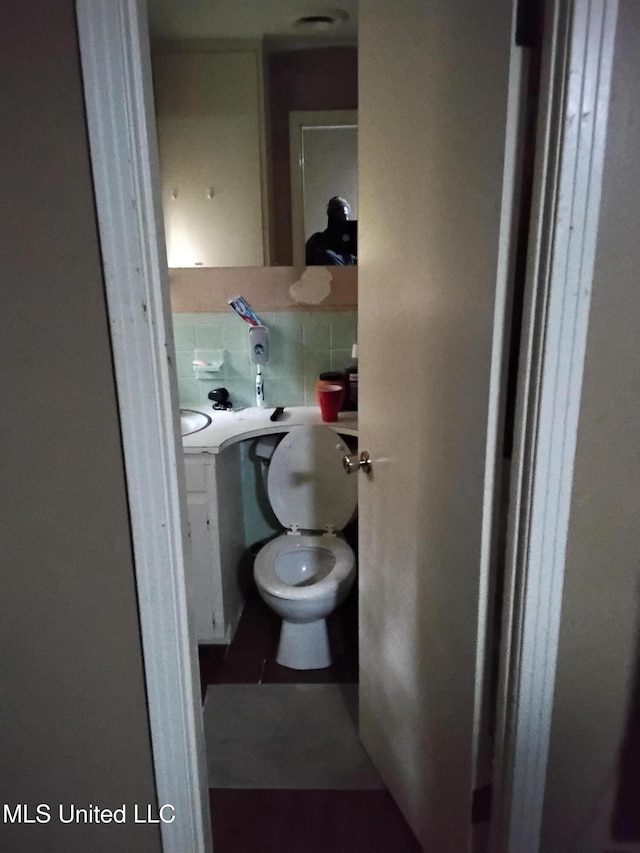 807 Line Dr, Forest, MS 39074 - bathroom featuring toilet and decorative backsplash