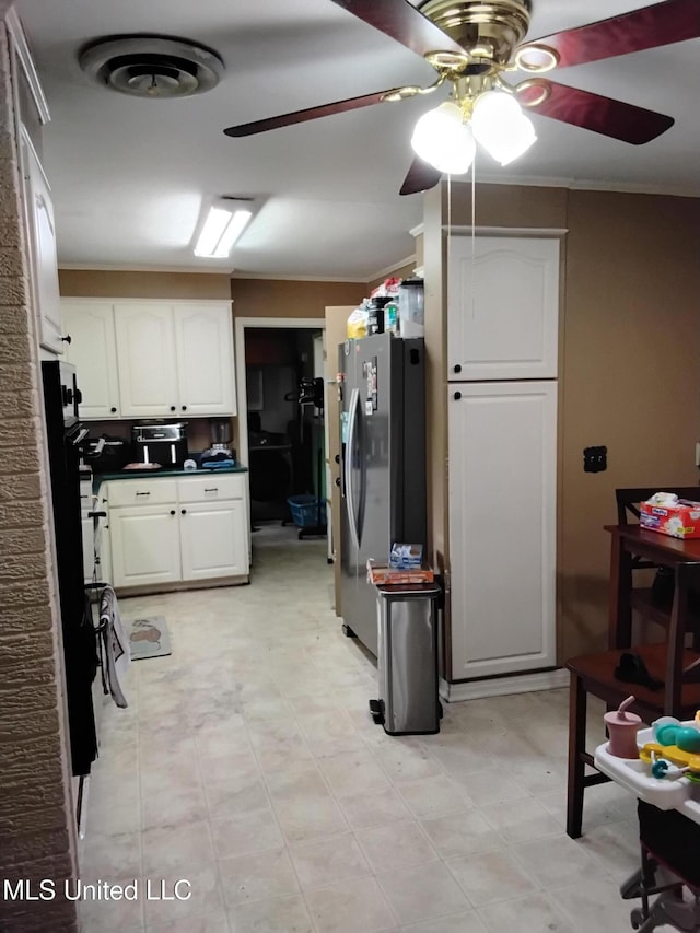 807 Line Dr, Forest, MS 39074 - kitchen featuring freestanding refrigerator, white cabinetry, ceiling fan, dark countertops, and light flooring