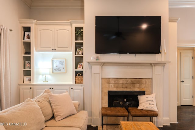 living room with crown molding, dark wood-type flooring, and a fireplace