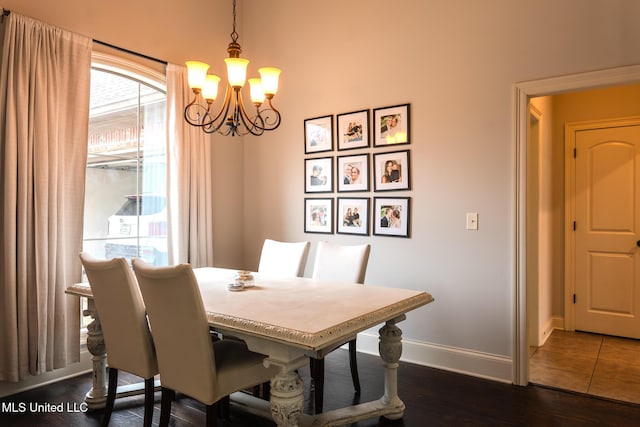 dining area featuring dark hardwood / wood-style flooring and a chandelier