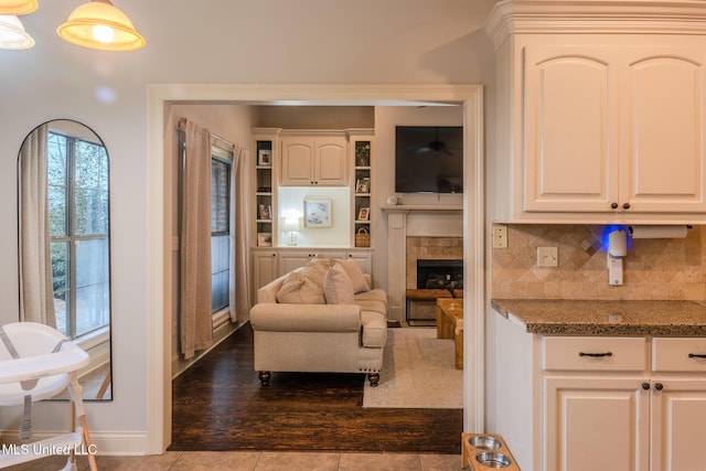 living room with a tile fireplace and light tile patterned flooring