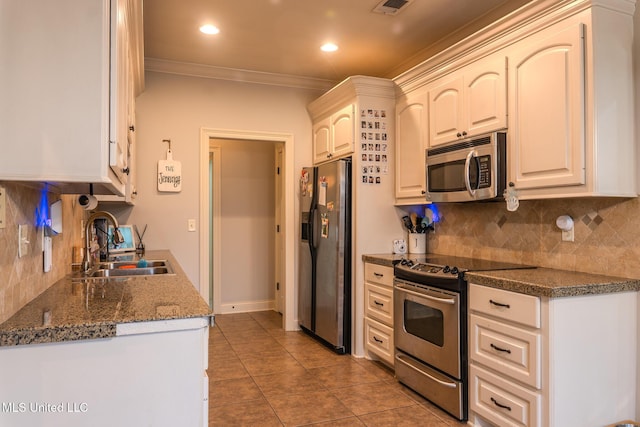 kitchen featuring sink, appliances with stainless steel finishes, tile patterned flooring, ornamental molding, and white cabinets