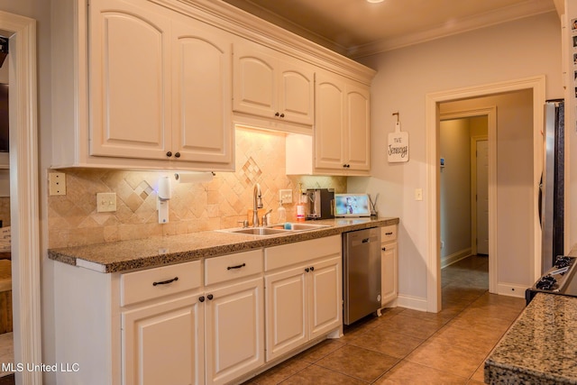 kitchen with sink, crown molding, white cabinets, stainless steel appliances, and backsplash