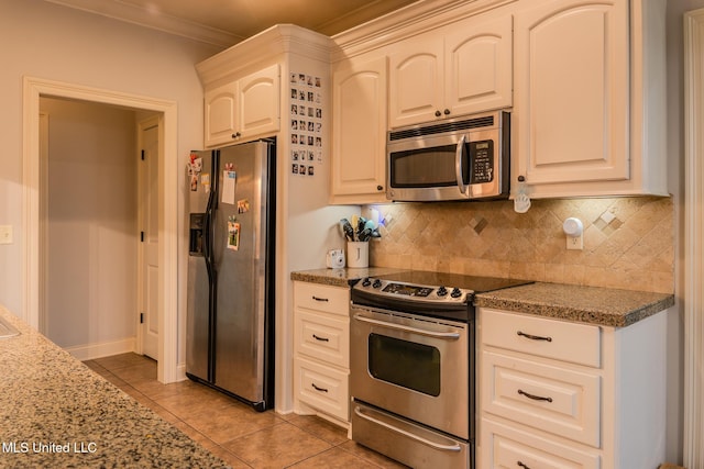 kitchen featuring white cabinetry, light tile patterned floors, stone counters, and appliances with stainless steel finishes