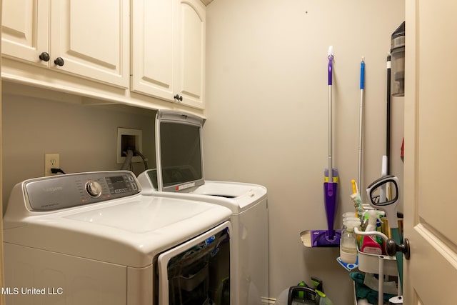 washroom with cabinets and washer and dryer