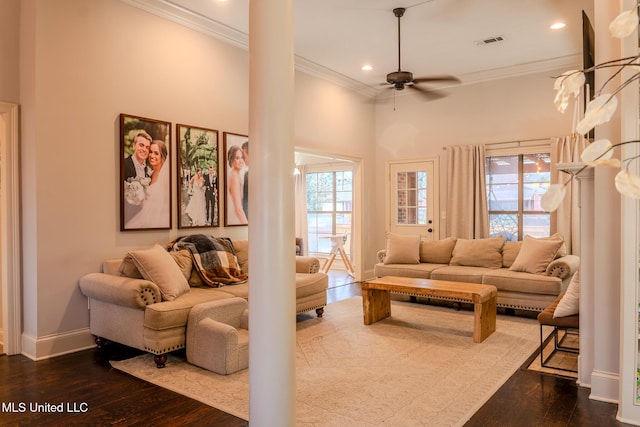 living room with hardwood / wood-style flooring, ornamental molding, a towering ceiling, and ceiling fan