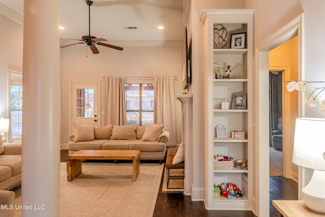 living room with dark hardwood / wood-style flooring, crown molding, built in features, and ceiling fan