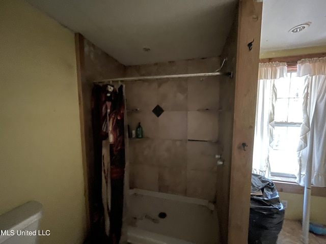 bathroom featuring a shower with curtain and toilet