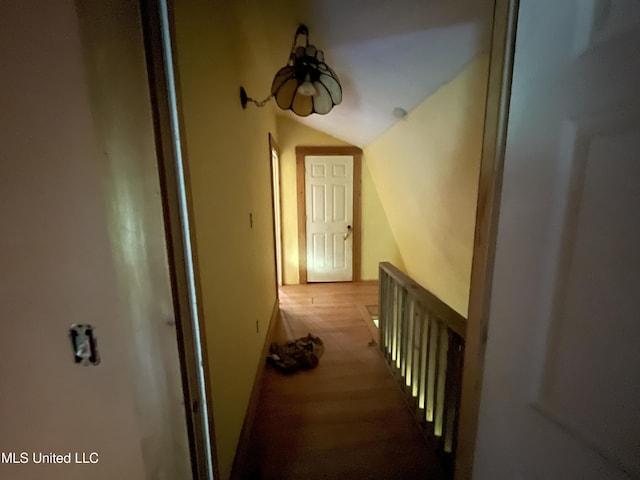 hall with lofted ceiling and hardwood / wood-style floors