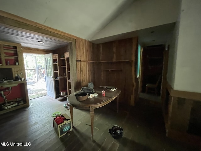 misc room with hardwood / wood-style flooring, vaulted ceiling, and wooden walls