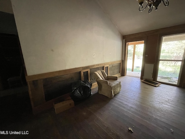 living area with lofted ceiling, dark hardwood / wood-style floors, and a notable chandelier