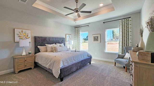 carpeted bedroom with a raised ceiling, ceiling fan, and crown molding