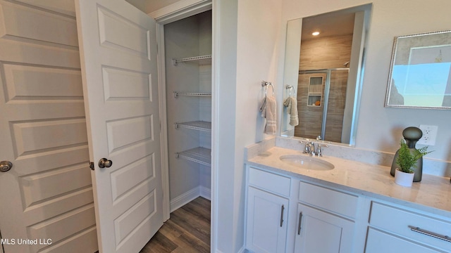 bathroom featuring hardwood / wood-style floors, vanity, and a shower with shower door