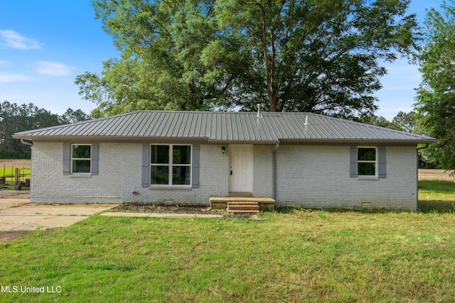 ranch-style home featuring metal roof, a front yard, and brick siding