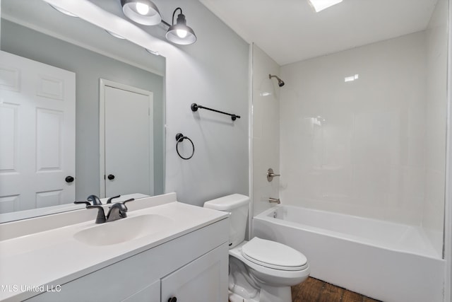 bathroom with wood finished floors, toilet, vanity, and tub / shower combination