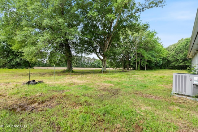 view of grassy yard with central AC