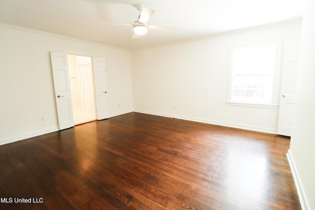 unfurnished room featuring dark wood-style floors, baseboards, a ceiling fan, and ornamental molding