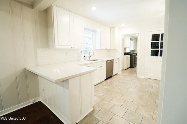 kitchen featuring a sink, a peninsula, white cabinets, light countertops, and dishwasher