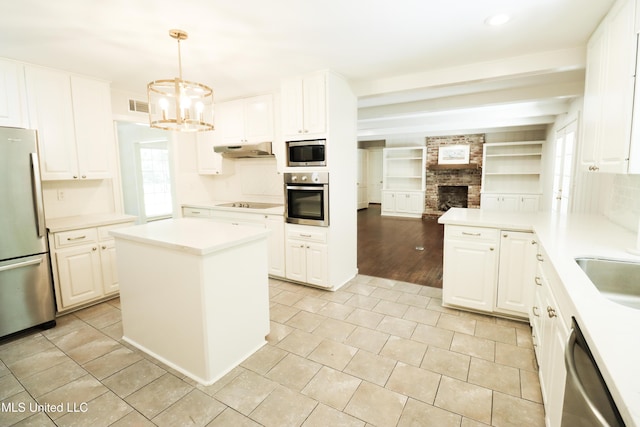 kitchen with visible vents, light countertops, white cabinets, under cabinet range hood, and appliances with stainless steel finishes