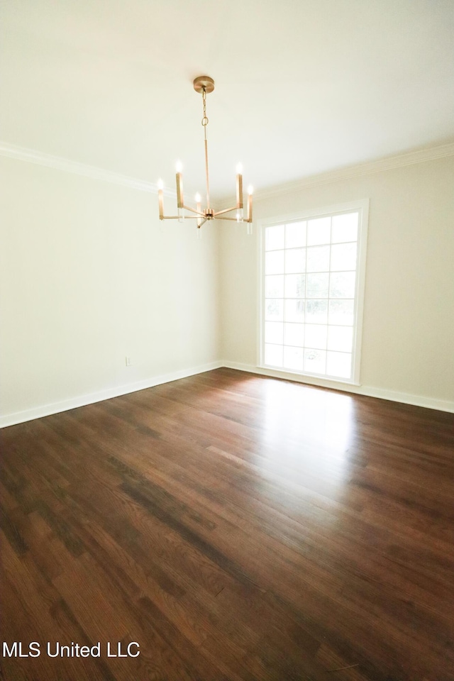 unfurnished room featuring a chandelier, baseboards, ornamental molding, and dark wood finished floors