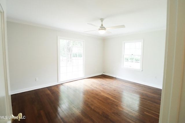 empty room with crown molding, wood finished floors, baseboards, and ceiling fan