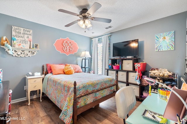 bedroom featuring wood finished floors, a textured ceiling, ceiling fan, and baseboards