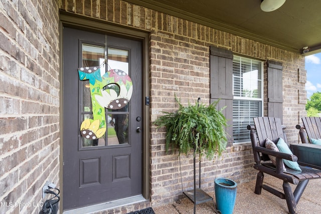 entrance to property with brick siding and a porch