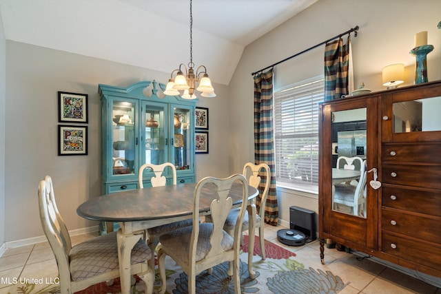 dining space with a chandelier, light tile patterned floors, vaulted ceiling, and baseboards