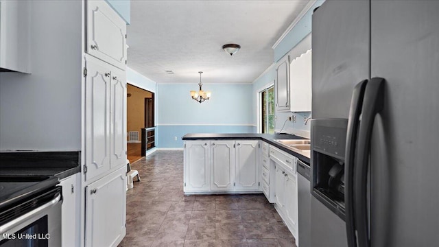 3222 Stage Rd, Morton, MS 39117 - kitchen featuring stainless steel appliances, a peninsula, dark countertops, a chandelier, and white cabinetry