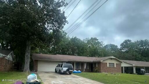 1218 Springdale Dr, Jackson, MS 39211 - ranch-style home featuring a garage, driveway, and a front lawn