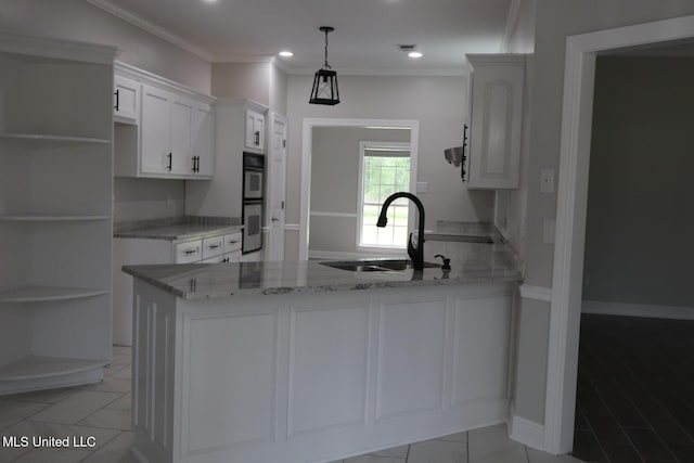 kitchen featuring a sink, a peninsula, light stone counters, double oven, and white cabinetry